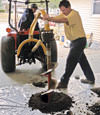 Digging a hole in the garage floor to make room for a wall anchor installation in Hackensack, NJ, New Jersey