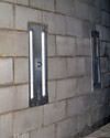 an inside view of foundation wall anchors installed along a basement wall to brace and repair the structure in Wayne
