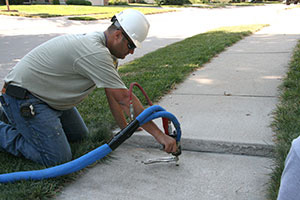 Technician raising sidewalk with PolyLevel® in Staten Island