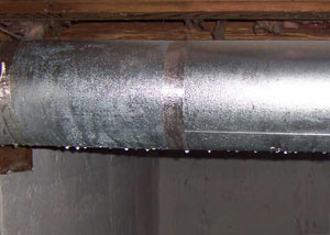 condensation collecting on an HVAC vent in a humid Brick basement