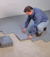 Contractors installing basement subfloor tiles and matting on a concrete basement floor in Brick, New Jersey & Pennsylvania
